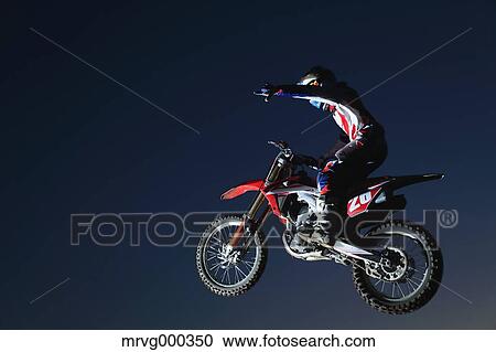 Motocross biker jumping over dirt track View Large Photo Image Stock Image - Motocross biker jumping over dirt track. Fotosearch