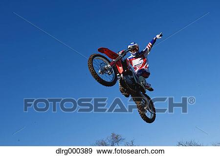 Motocross biker jumping over dirt track View Large Photo Image Stock Photo - Motocross biker jumping over dirt track. Fotosearch