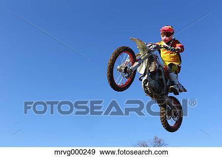 Motocross biker jumping over dirt track View Large Photo Image Stock Photo - Motocross biker jumping over dirt track. Fotosearch