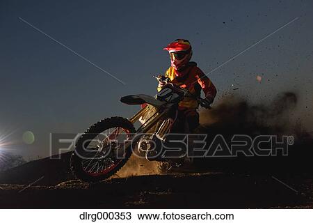 Stock Image - Motocross biker on dirt track. Fotosearch