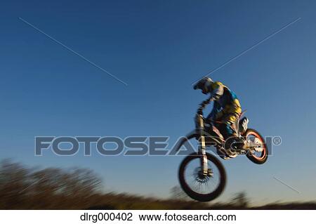 Stock Image - Motocross biker on dirt track. Fotosearch