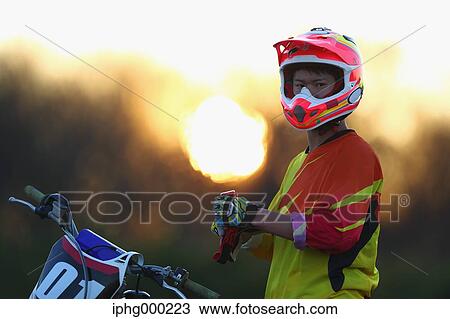 Stock Image - Motocross biker on dirt track. Fotosearch