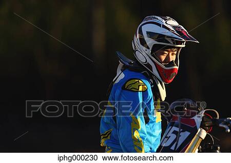 Stock Image - Motocross biker on dirt track. Fotosearch