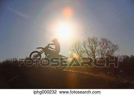 Stock Image - Motocross biker on dirt track. Fotosearch