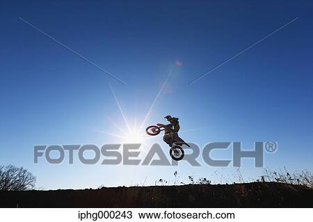 Stock Image - Motocross biker on dirt track. Fotosearch