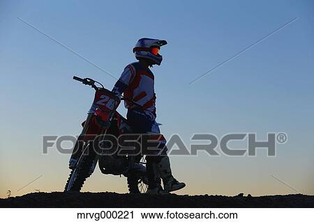 Stock Image - Motocross biker on dirt track. Fotosearch