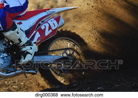 Stock Photo - Motocross biker on dirt track. Fotosearch