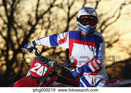 Stock Photo - Motocross biker on dirt track. Fotosearch