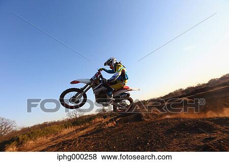 Stock Photo - Motocross biker on dirt track. Fotosearch