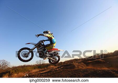 Stock Photo - Motocross biker on dirt track. Fotosearch