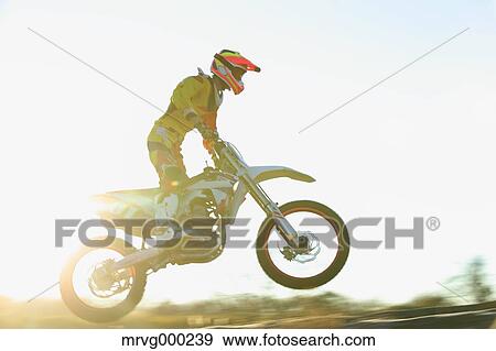 Stock Photo - Motocross biker on dirt track. Fotosearch