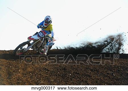 Stock Photo - Motocross biker on dirt track. Fotosearch