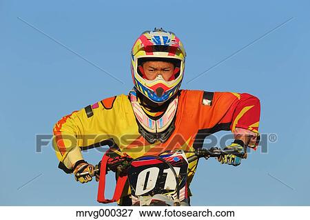 Stock Photo - Motocross biker on dirt track. Fotosearch