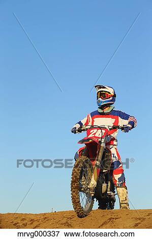Stock Photo - Motocross biker on dirt track. Fotosearch