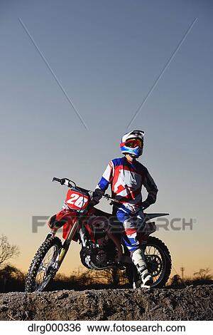 Stock Photograph - Motocross biker on dirt track. Fotosearch