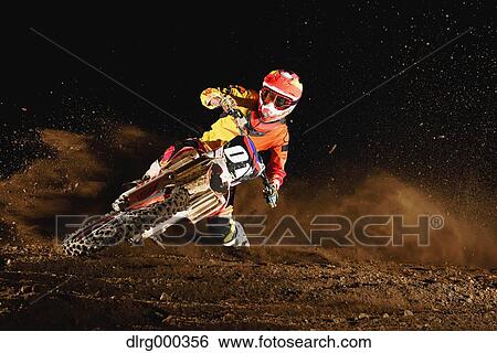 Stock Photograph - Motocross biker on dirt track. Fotosearch