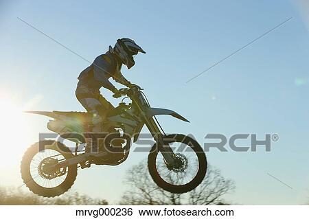 Stock Photograph - Motocross biker on dirt track. Fotosearch