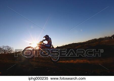 Stock Photography - Motocross biker on dirt track. Fotosearch
