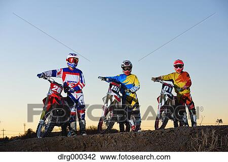 Stock Image - Motocross bikers on dirt track. Fotosearch