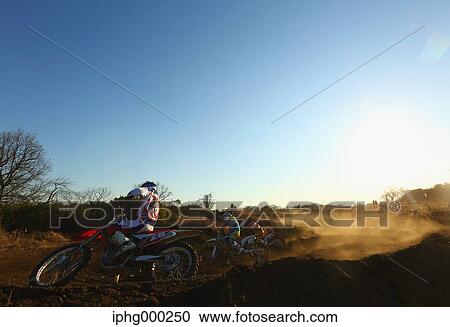 Stock Image - Motocross bikers on dirt track. Fotosearch