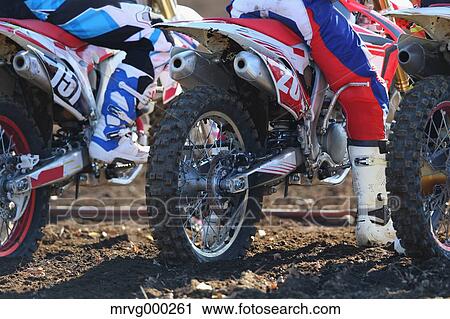 Stock Image - Motocross bikers on dirt track. Fotosearch