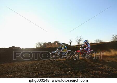 Stock Photo - Motocross bikers on dirt track. Fotosearch