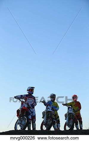 Stock Photograph - Motocross bikers on dirt track. Fotosearch