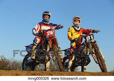Stock Photograph - Motocross bikers on dirt track. Fotosearch