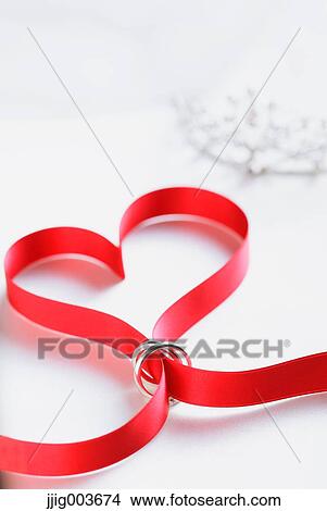 Red ribbon and wedding rings View Large Photo Image Picture - Red ribbon and wedding rings. Fotosearch