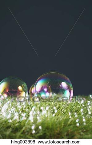 Stock Photo - Soap bubbles on grass. Fotosearch