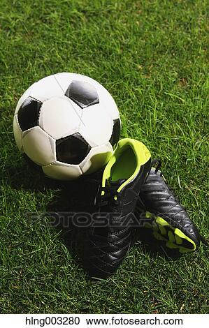 Stock Image - Soccer ball and shoes on grass. Fotosearch