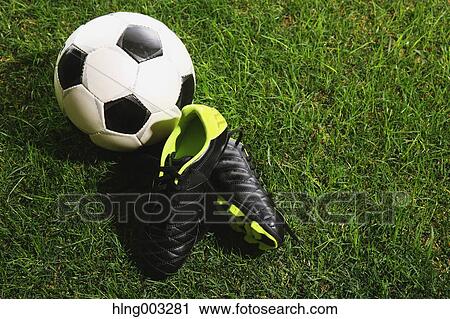Stock Image - Soccer ball and shoes on grass. Fotosearch