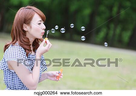 Picture - Young attractive Japanese woman in a city park. Fotosearch