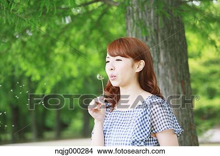 Picture - Young attractive Japanese woman in a city park. Fotosearch