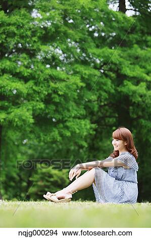 Picture - Young attractive Japanese woman in a city park. Fotosearch