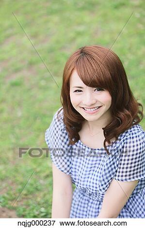Stock Photo - Young attractive Japanese woman in a city park. Fotosearch