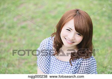 Stock Photo - Young attractive Japanese woman in a city park. Fotosearch