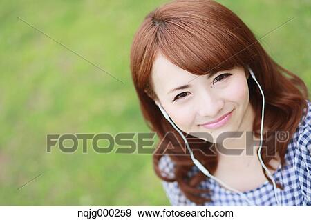 Stock Photo - Young attractive Japanese woman in a city park. Fotosearch