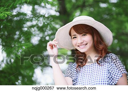Stock Photo - Young attractive Japanese woman in a city park. Fotosearch