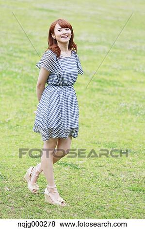 Stock Photo - Young attractive Japanese woman in a city park. Fotosearch