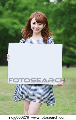 Stock Photo - Young attractive Japanese woman in a city park. Fotosearch