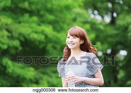 Young attractive Japanese woman in a city park View Large Photo Image Stock Photograph - Young attractive Japanese woman in a city park. Fotosearch