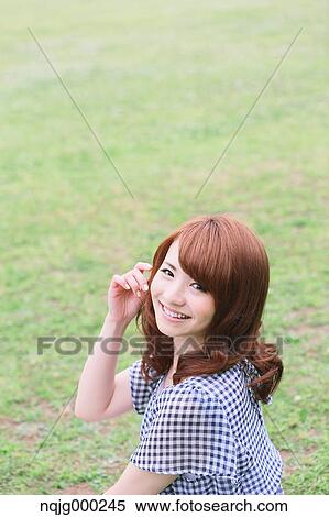 Young attractive Japanese woman in a city park View Large Photo Image Stock Photography - Young attractive Japanese woman in a city park. Fotosearch