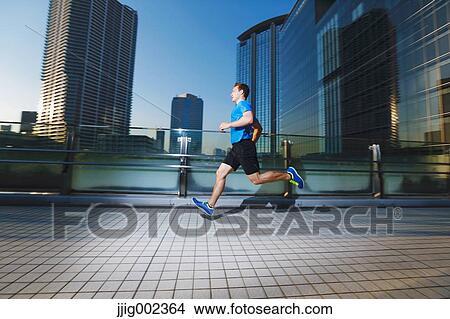 Young Caucasian man running in metropolitan area View Large Photo Image Picture - Young Caucasian man running in metropolitan area. Fotosearch
