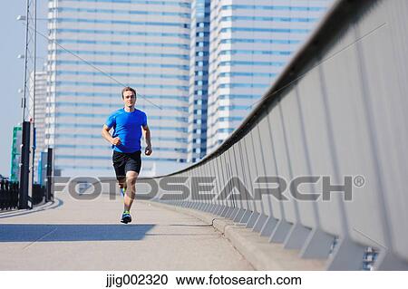 Young Caucasian man running in metropolitan area View Large Photo Image Stock Image - Young Caucasian man running in metropolitan area. Fotosearch