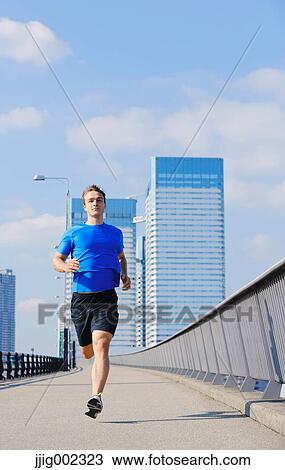 Young Caucasian man running in metropolitan area View Large Photo Image Stock Image - Young Caucasian man running in metropolitan area. Fotosearch