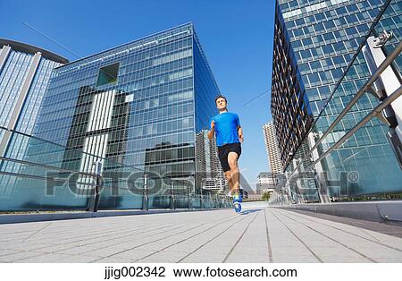 Young Caucasian man running in metropolitan area View Large Photo Image Stock Image - Young Caucasian man running in metropolitan area. Fotosearch