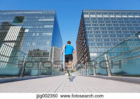 Young Caucasian man running in metropolitan area View Large Photo Image Stock Image - Young Caucasian man running in metropolitan area. Fotosearch