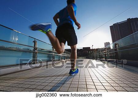Young Caucasian man running in metropolitan area View Large Photo Image Stock Image - Young Caucasian man running in metropolitan area. Fotosearch