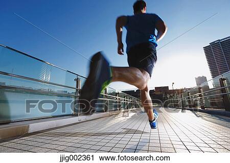 Young Caucasian man running in metropolitan area View Large Photo Image Stock Image - Young Caucasian man running in metropolitan area. Fotosearch